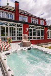 a swimming pool with two chairs and a house at Villa familiar - Jacuzzi - Children's Area in Bacoy