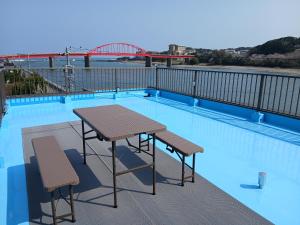 a table and two chairs next to a swimming pool at ゲストハウスMoana 那珂湊おさかな市場徒歩5分,9名可,BBQ可 in Hitachinaka