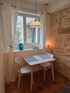 a table and chairs in a room with a window at The Little Hideaway - La Petite Maison Cachée in Noyers