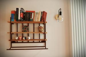 a book shelf on a wall with books at The Little Hideaway - La Petite Maison Cachée in Noyers