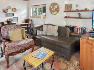 a living room with a leather couch and a chair at Casita Adobe in Grand Junction