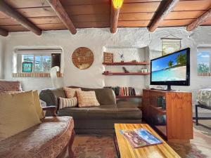 a living room with a couch and a flat screen tv at Casita Adobe in Grand Junction