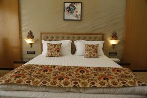 a bedroom with a large bed with two pillows at Hotel Jannat Celebration in Wani