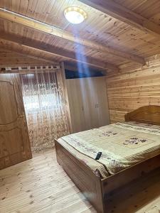 a bedroom with a bed in a wooden room at Guesthouse Katerina in Përmet