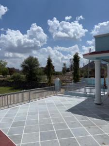 a balcony with a fence and a blue sky with clouds at The Celestine Villa in Thūr