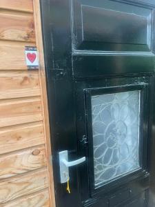 a black door with a glass window on it at PipowagenSiëester in Ommen