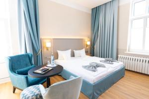 a hotel room with a bed and a table and a chair at Hotel Germania in Bansin