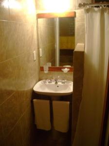 y baño con lavabo y espejo. en Cabaña Newen en Capilla del Monte