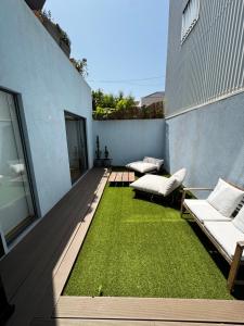 a patio with two couches and grass on a building at Sea Breeze - Espinho Beach in Espinho