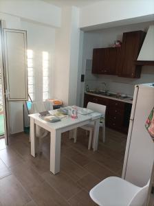 a kitchen with a white table and chairs in it at Brezza Marina in Cirella