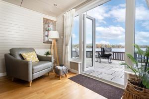 a living room with a chair and a sliding glass door at Keer Lodge a lakeshore haven Pine Lake Resort in Carnforth