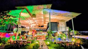 a restaurant with tables and chairs at night at Cargo Remote Mui Ne in Phan Thiet