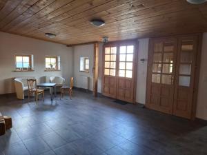 a room with a table and chairs and wooden ceilings at Chata pod Červenou studňou in Banská Štiavnica +17 photos