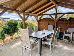a table and chairs on a patio under a pergola at Gemütliche 2-Zimmer-Ferienwohnung mit Garten in Mittenwalde