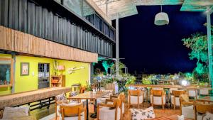 a restaurant with tables and chairs in a room at Cargo Remote Mui Ne in Phan Thiet