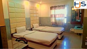 a room with two beds and a sink at Hotel Jyoti Sanjay in Pūrnia