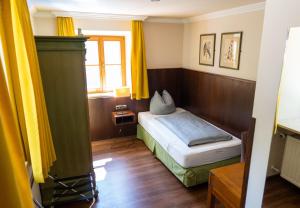 a small bedroom with a bed and a window at Noon Mirch Hotel Restaurant in Eching
