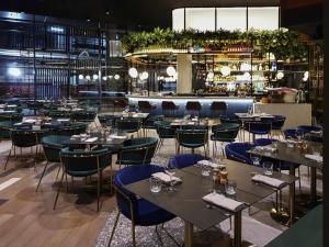 a restaurant with tables and chairs and a bar at The Sebel Melbourne Moonee Ponds in Melbourne