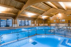 a large swimming pool with a wooden ceiling at Keer Lodge a lakeshore haven Pine Lake Resort in Carnforth