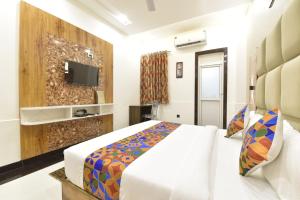 a hotel room with a bed and a tv at Hotel Shaily Royal in Kota