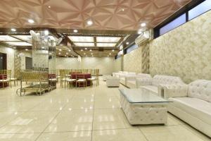 a large room with white furniture and a dining room at Hotel Shaily Royal in Kota