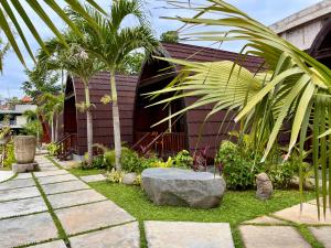 a garden with a palm tree and a building at Dalung Tropical in Dalung