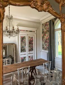 a dining room with a table and a mirror at Les séquoias géants in Saint-Martin-aux-Arbres