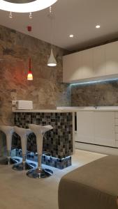 uma cozinha com dois bancos brancos e um balcão em Apartment Orlando Costa Adeje em Adeje