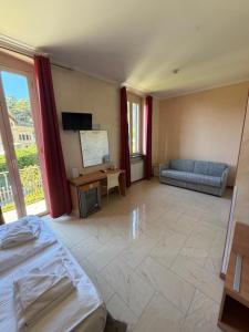 a large room with a bed and a couch at Hotel Villa Flora in Bogliasco