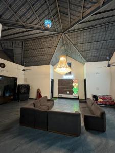 a large living room with a couch and a chandelier at Infinity farm and garden in Bhopal