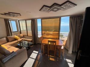 a living room with a table and a view of the ocean at private apparemment with ocean view in Taghazout