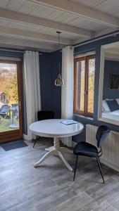 a table and a chair in a room with a bed at BonBon Chambre d'hôtes in Saint-Julien-de-Lampon