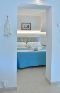 um quarto com uma cama azul num quarto em Albergo Diffuso Monopoli em Monopoli