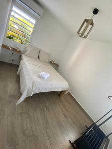 a small bedroom with a bed and a window at Maison Dousè in Sainte-Rose