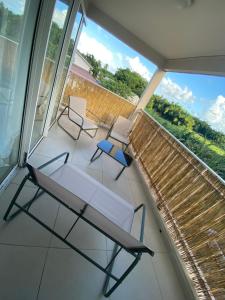 a balcony with two chairs and a bench on it at Maison Dousè in Sainte-Rose