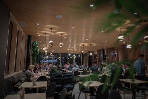 a group of people sitting at tables in a restaurant at AVES Hotel Savognin in Savognin