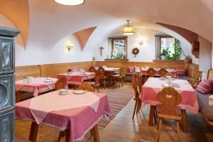 ミッタージルにあるPension Oberbräuのピンクのテーブルクロスが敷かれたテーブルと椅子が備わるレストラン