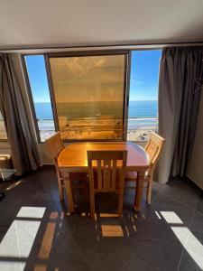 a dining room with a table and chairs and a view of the ocean at private apparemment with ocean view in Taghazout