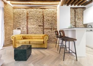a living room with a yellow couch and a table at Apartamentos El Marqués in Granada