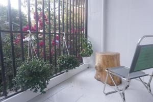 a balcony with a fence with flowers and a chair at Hyn's House in Danang