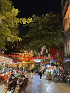 a group of people walking down a street at night at Hanoi Street Hotel in Hanoi