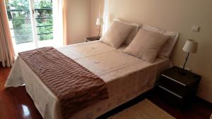 a large bed in a bedroom with a window at Vila Régia in Funchal