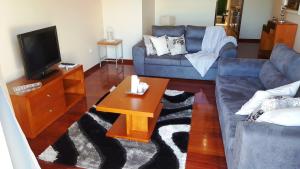 a living room with a blue couch and a coffee table at Vila Régia in Funchal