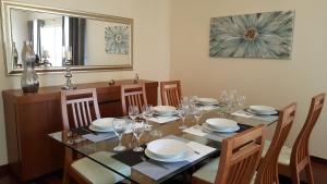 a dining room table with chairs and a large mirror at Vila Régia in Funchal