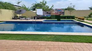 a swimming pool in a yard with an umbrella at Leina Life-Style Comfy Studio Balcony near Mactan Airport in Bankal +5 photos