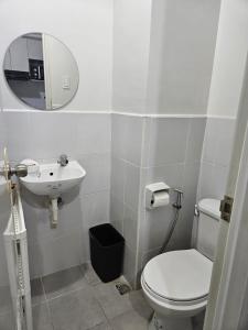 a bathroom with a toilet and a sink and a mirror at Leina Life-Style Comfy Studio Balcony near Mactan Airport in Bankal