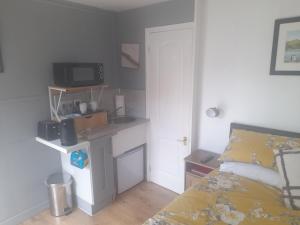 a bedroom with a bed and a desk with a television at The Bolt Hole in Barmouth