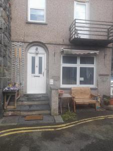 a house with a bench and a white door at The Bolt Hole in Barmouth