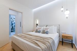 a white bedroom with a large bed with pillows at Memoa Residence Preveza in Preveza