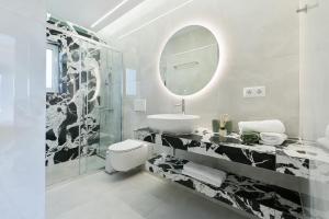 a white bathroom with a sink and a mirror at Memoa Residence Preveza in Preveza